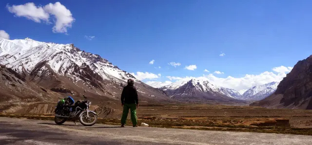 Lukas and his motorbike on a road through the snowy Himalayas